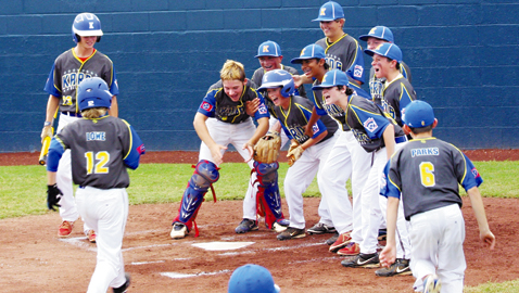 PHOTO BY CAROLYN GRENKOSKI Jubilant Karns teammates await for Mikey Lowe to touch home plate after he hit smacked a grand slam home run in a 15-5 win over Tullahoma in the State Little League tournament at Clarksville Thursday night. 
