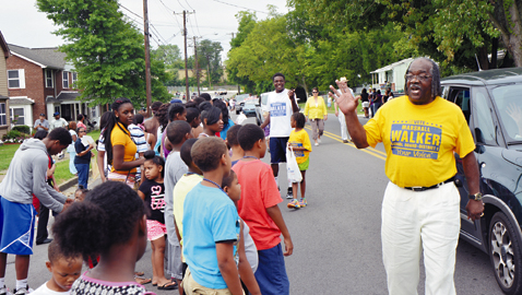 photo by dan andrews. Marshall Walker, candidate for School Board 1st District, greets a huge turnout of residents during last Saturday’s annual Lonsdale Homecoming Parade.