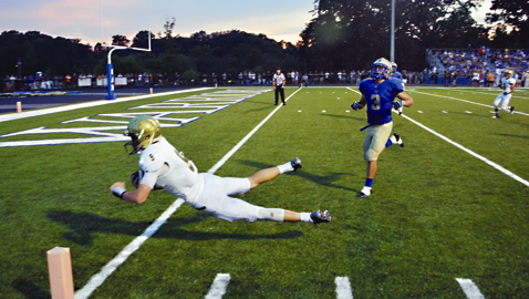 By Dan Andrews. Catholic quarterback Zac Jancek avoids CAK defender Wyatt Eaton and plunges into the end zone. Jancek rushed for 95 yards and accounted for five touchdowns in the Irish’s 70-23 win over the Warriors in the District 4-AA opener for both teams.