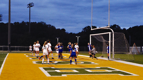 Photo by Dan Andrews. CAK freshman goalkeeper Skyler Woidtke faces a shot in front of a crowded net in Thursday night’s District 4-A/AA Championship match. Catholic’s Ashley Hickman scored a hat trick to lead the Lady Irish to a 3-1 comeback win over the Lady Warriors.
