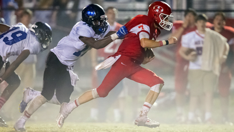 PHOTO BY TIM GANGLOFF / hatpix.com Halls’ Colby Jones runs the ball through the fog Friday night, while Karns’ Stedman Love tries to tackle him in the District 3-AAA game. The host Red Devils finished strong to get past Mother Nature and the Beavers 47-35.