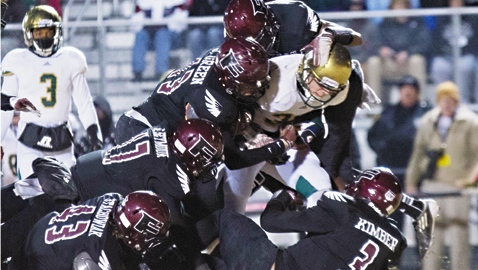PHOTO BY JOHN VALENTINE A flock of Falcon defenders put the stop on a Catholic player in Fulton’s 51-14 playoff victory Friday night at Bob Black Field.