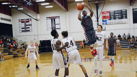 South-Doyle's Jarquese Goines leaps over Kingsport Dobyns-Bennett two Kingsport Dobyns-Bennett defenders to attempt a shot in a tournament game last Monday night. Goines scored 17 points in the Cherokees' 78-63 loss at Central High School. Photo by Dan Andrews.