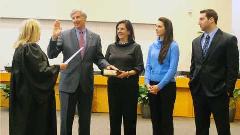 Newly appointed 5th District Commissioner John Schoonmaker takes the oath administered by Circuit Court Judge Kristi Davis as his family watches. His oath was taken just before the regular meeting of the commission last Monday. (Photo by Mike Steely) 