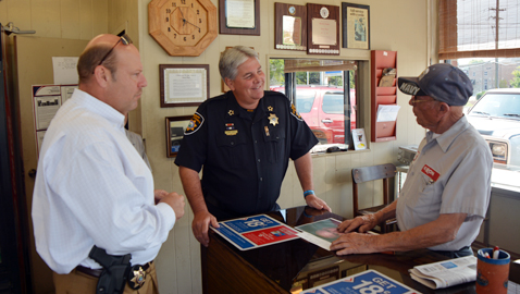 Photo by Dan Andrews. Sheriff Jones and Deputy Chief Lee Tramel take a hands on approach involving protecting seniors year round. Jones and Tramel personally follow up with Alvin Frye in regards to an arrest made resulting from a  burglary at his business.