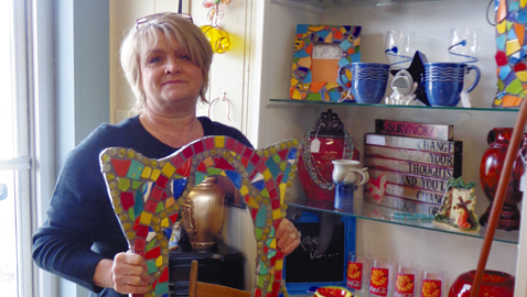 Photo by Mike Steely Jama Williams displays some of the locally made crafts inside Not Too Shabby Consignment. The store features clothing, furniture, jewelry, crafts, and much more.