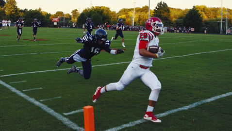 Photo by Dan Andrews. Halls High School’s Matthew Runge-Gold (29) scampers past Anderson County’s Everett Dews in Thursday night’s portion of the K.O.C. Kickoff Classic at Central High School. Runge-Gold caught a pair of touchdown passes for the Red Devils, who played to a 14-14 tie against the Mavericks.