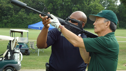 Dr. Kim tries out the rifle shot at his 2013 tournament.